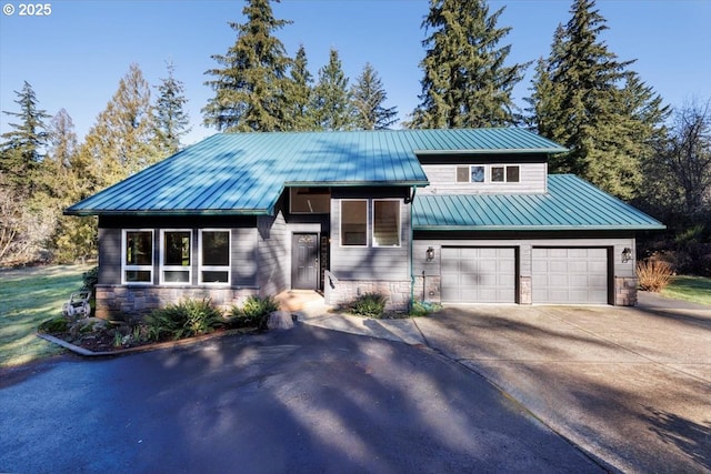 view of front of house featuring a garage, metal roof, a standing seam roof, and concrete driveway