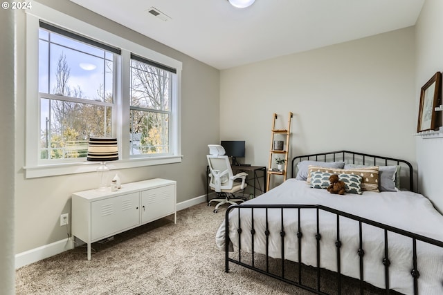 bedroom featuring light carpet and multiple windows