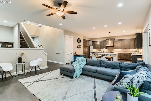 living room with dark hardwood / wood-style floors, ceiling fan, and sink