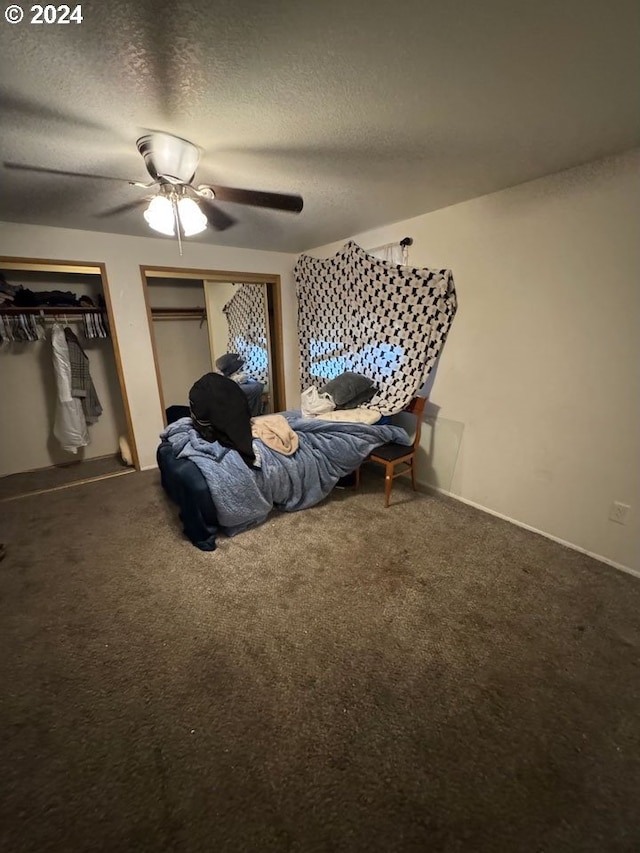 bedroom with ceiling fan, carpet floors, and a textured ceiling