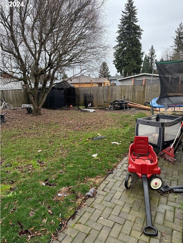 view of yard featuring a trampoline and a patio area