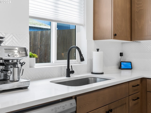 kitchen featuring dishwasher, tasteful backsplash, and sink