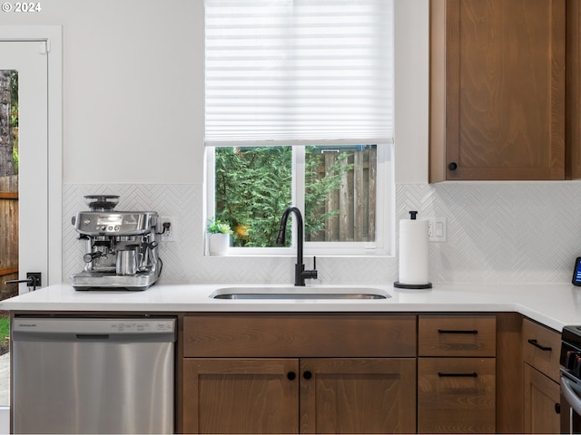 kitchen with backsplash, sink, and appliances with stainless steel finishes