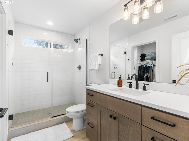 bathroom featuring toilet, a shower with door, vanity, and hardwood / wood-style flooring