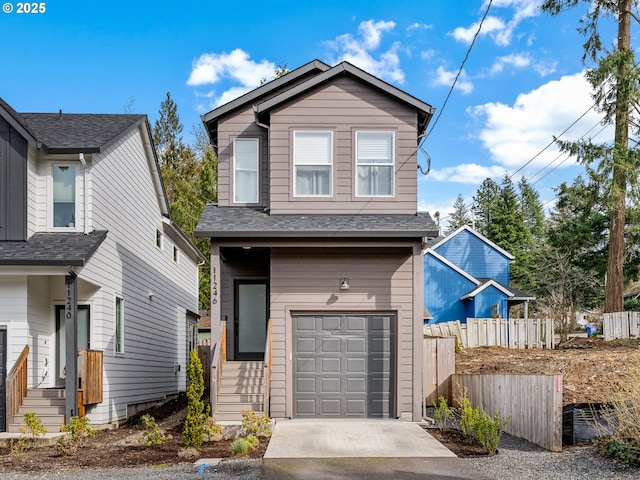 traditional-style home featuring an attached garage, a shingled roof, fence, and concrete driveway
