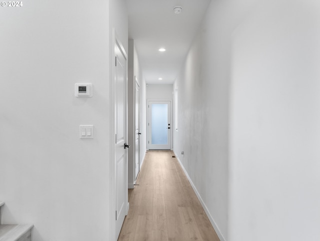 hallway with light wood-style flooring, stairs, baseboards, and recessed lighting