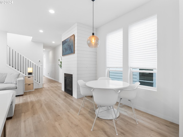 dining area featuring recessed lighting, stairway, a fireplace, and light wood-type flooring