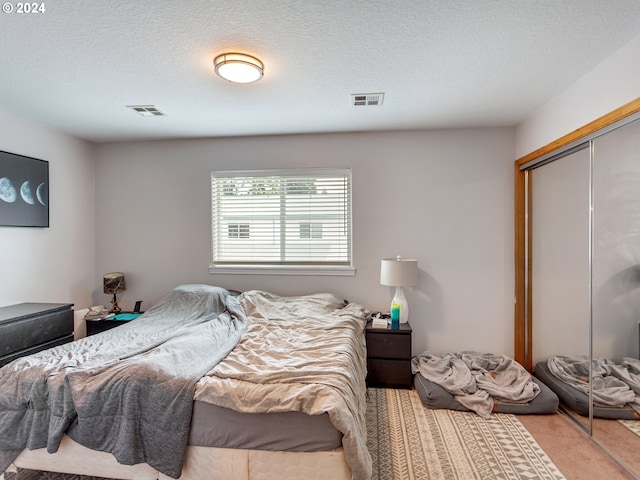 bedroom with a textured ceiling and a closet