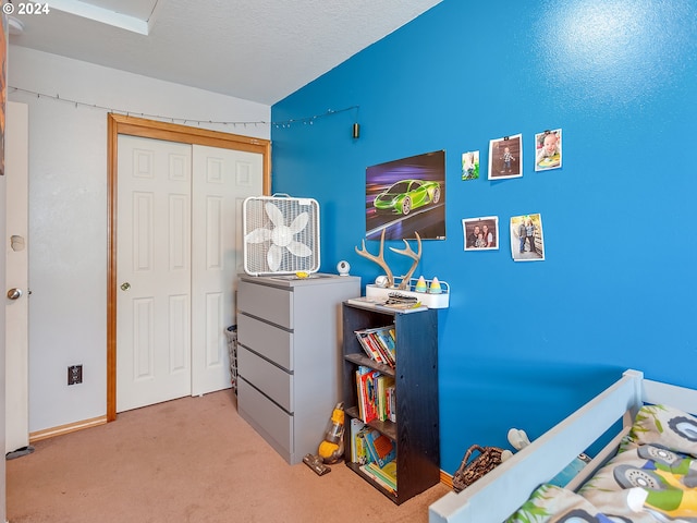 bedroom with light colored carpet, a textured ceiling, a closet, and lofted ceiling