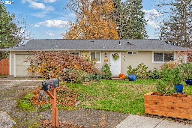 ranch-style house with a garage and a front lawn