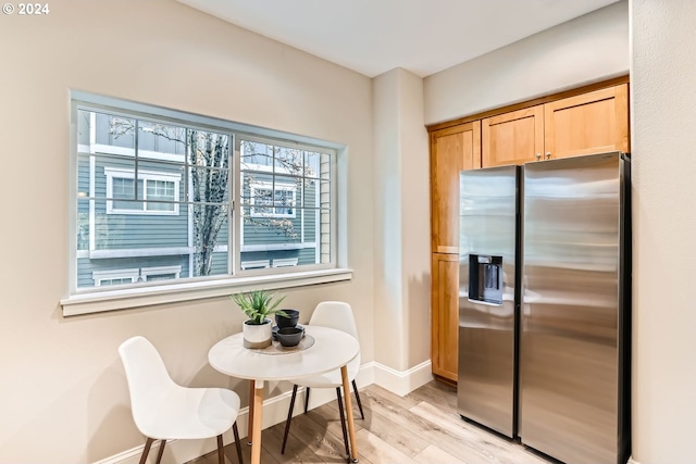 kitchen with stainless steel refrigerator with ice dispenser and light hardwood / wood-style flooring