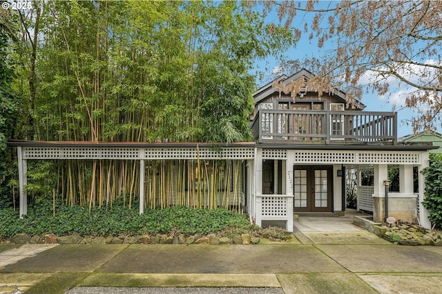 view of front of house with a wooden deck and french doors