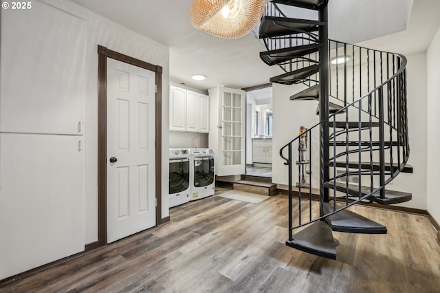 laundry area featuring cabinets, washer and clothes dryer, and hardwood / wood-style floors