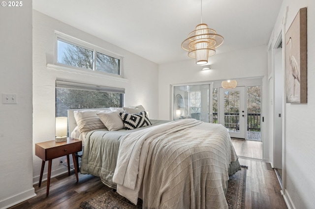 bedroom featuring access to exterior, multiple windows, and dark hardwood / wood-style floors