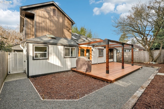 back of property with a pergola and a wooden deck