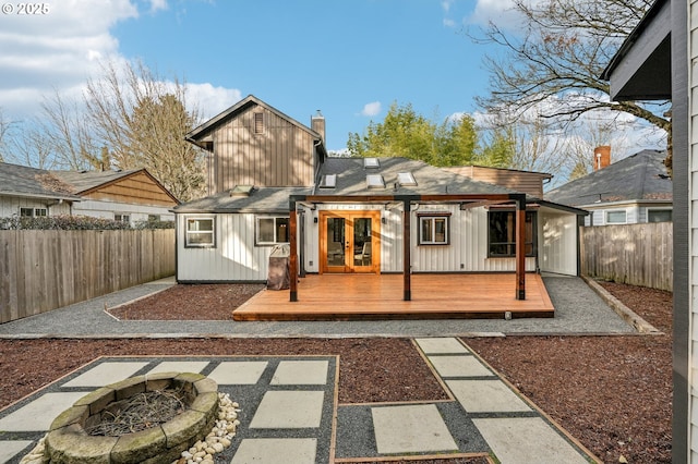 back of property featuring a wooden deck and a fire pit