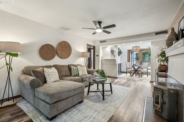 living room with hardwood / wood-style flooring, a textured ceiling, and ceiling fan