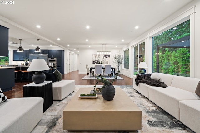 living room featuring wood-type flooring and an inviting chandelier