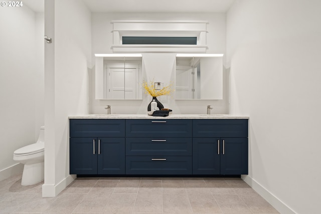 bathroom with tile patterned flooring, vanity, and toilet