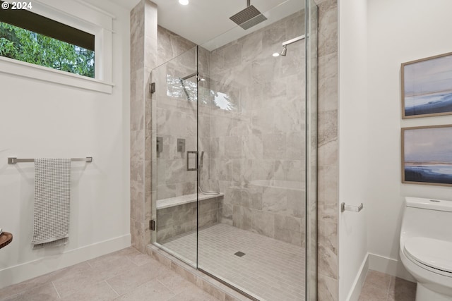 bathroom featuring tile patterned floors, toilet, and a shower with shower door