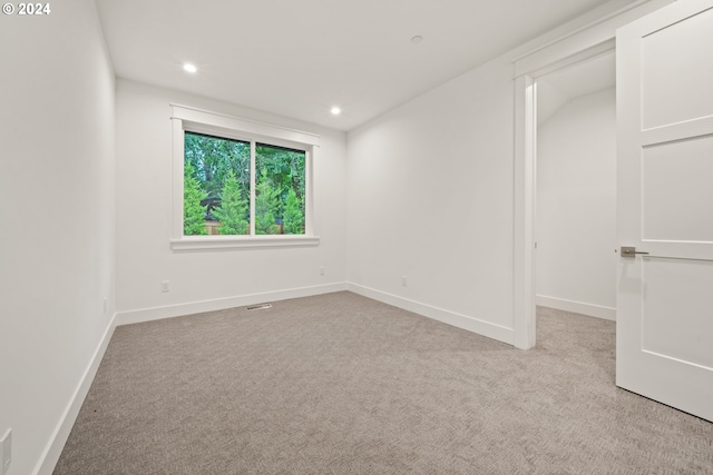 unfurnished room featuring light carpet