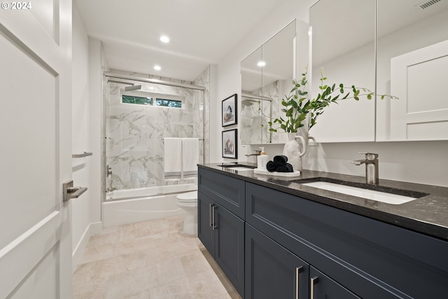 full bathroom featuring vanity, bath / shower combo with glass door, and toilet