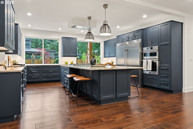 kitchen with pendant lighting, a center island, stainless steel appliances, and a breakfast bar area