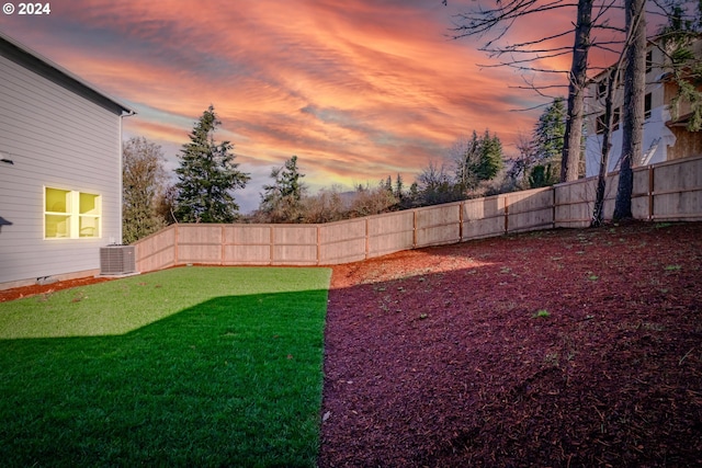 yard at dusk with central AC unit