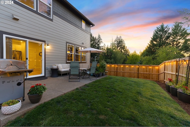 yard at dusk featuring a patio