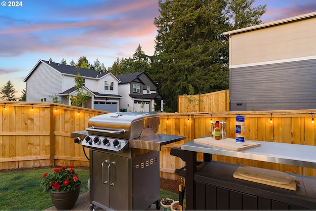 patio terrace at dusk featuring area for grilling