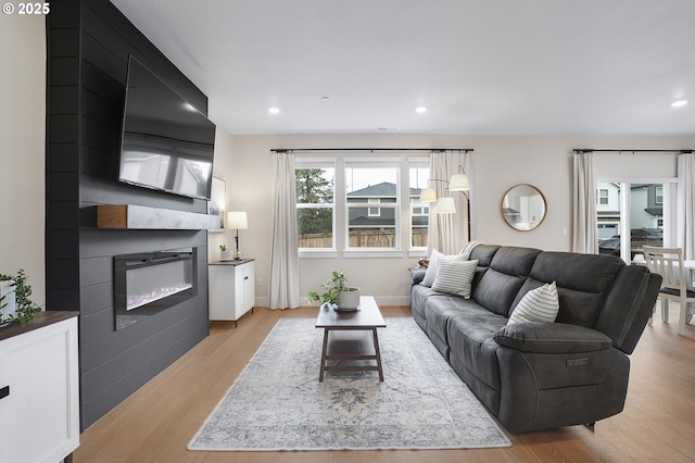 living room with a fireplace and light wood-type flooring