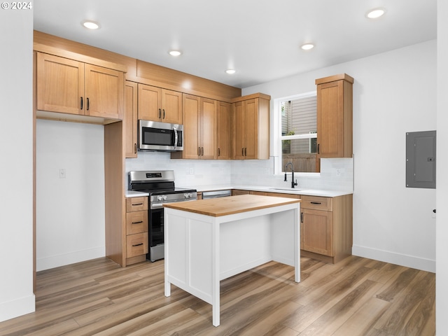 758 NE 91st Ave Unit 1, Portland, OR 97220 - kitchen with electric panel, backsplash, a sink, butcher block counters, and stainless steel appliances