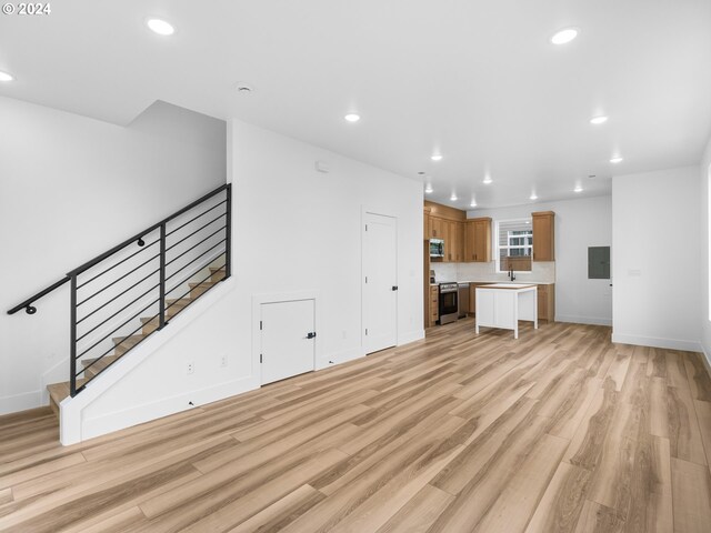 758 NE 91st Ave Unit 1, Portland, OR 97220 - unfurnished living room with electric panel, stairway, light wood finished floors, and recessed lighting