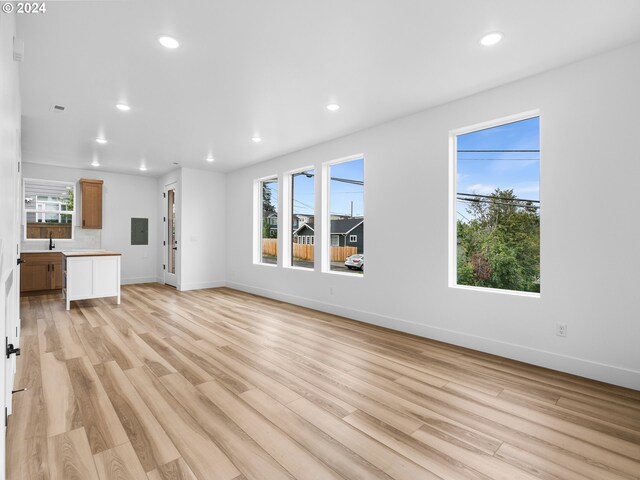 758 NE 91st Ave Unit 1, Portland, OR 97220 - unfurnished living room with electric panel, baseboards, light wood-type flooring, and recessed lighting