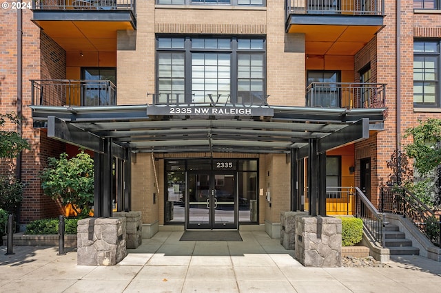 view of exterior entry with a balcony