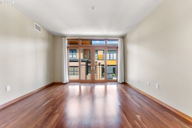 empty room with french doors and hardwood / wood-style flooring