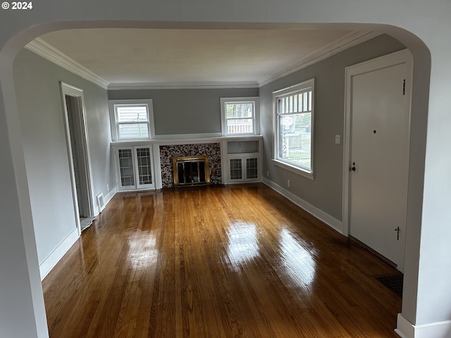 unfurnished living room featuring ornamental molding, hardwood / wood-style flooring, and a tile fireplace