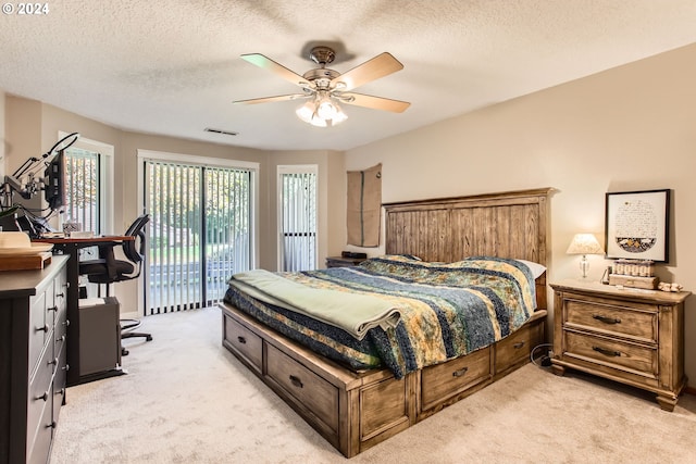 bedroom with a textured ceiling, access to outside, light colored carpet, and ceiling fan