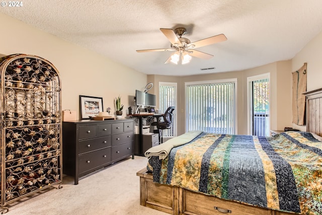 carpeted bedroom with ceiling fan, a textured ceiling, and access to exterior