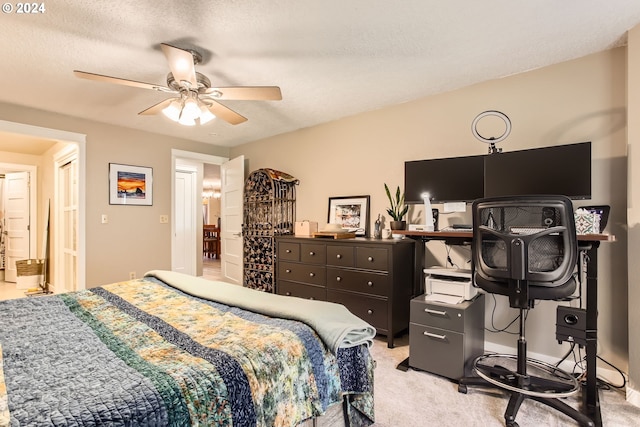 carpeted bedroom featuring a textured ceiling and ceiling fan