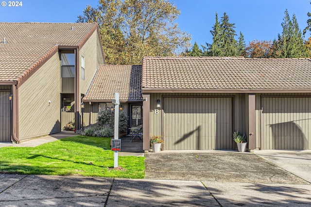 view of property featuring a garage and a front yard