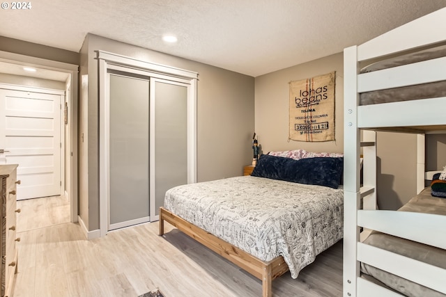 bedroom featuring a closet, hardwood / wood-style floors, and a textured ceiling