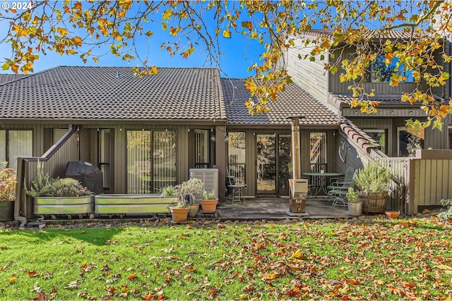 back of house with a lawn and a patio area