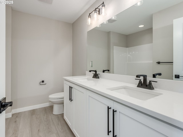 838 NW 178th Way, Ridgefield, WA 98642 - bathroom with wood finished floors, toilet, double vanity, and baseboards