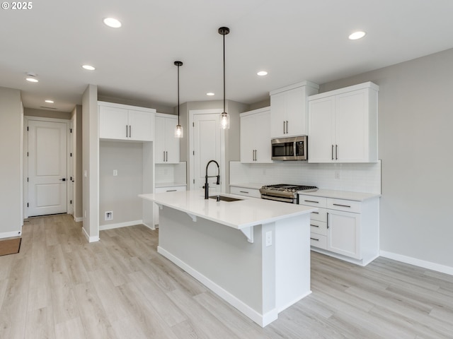 838 NW 178th Way, Ridgefield, WA 98642 - kitchen featuring stainless steel appliances, a sink, light wood-type flooring, baseboards, and recessed lighting