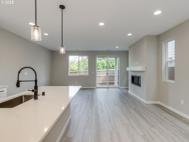 838 NW 178th Way, Ridgefield, WA 98642 - kitchen featuring a sink, recessed lighting, baseboards, decorative light fixtures, and light wood finished floors