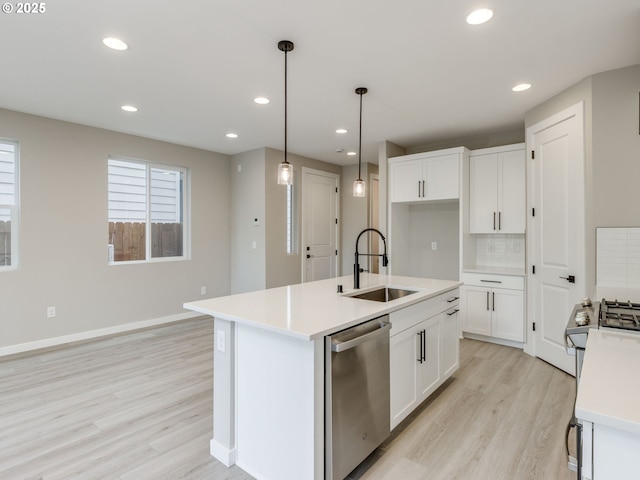 838 NW 178th Way, Ridgefield, WA 98642 - kitchen with stainless steel appliances, a sink, light wood-type flooring, white cabinets, and light countertops