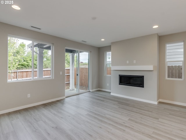 838 NW 178th Way, Ridgefield, WA 98642 - unfurnished living room with light wood-style floors, baseboards, recessed lighting, and a glass covered fireplace