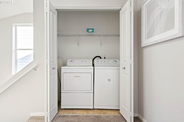 clothes washing area with separate washer and dryer and light carpet