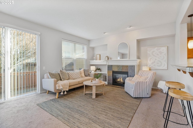 living room with a tiled fireplace and light colored carpet